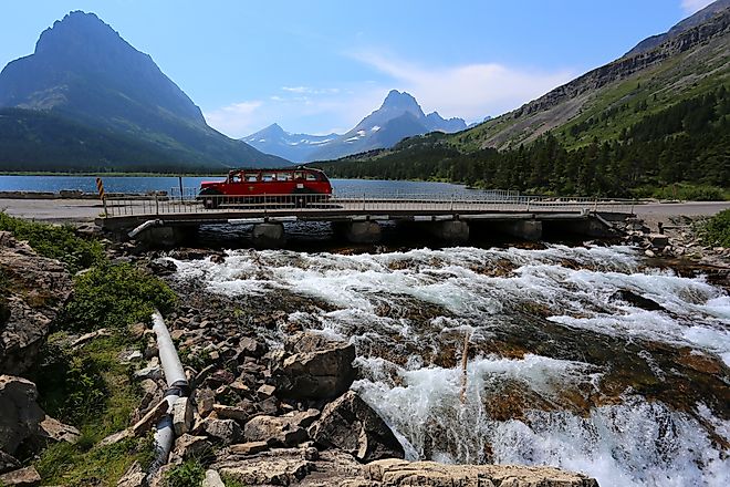 Red Tour Bus passing through the Glacier National Park, Montana.