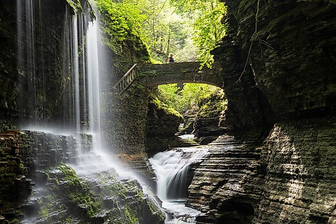 Rainbow Falls with a lady on bridge at Watkins Glen State Park