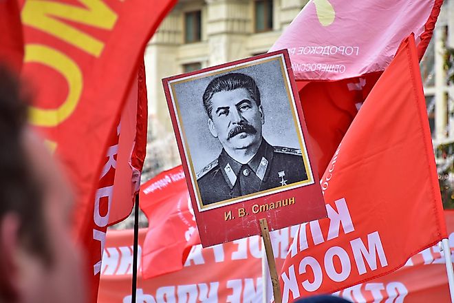 The flag of the Soviet Union (USSR) waving in the wind against the background of the monument to Lenin.