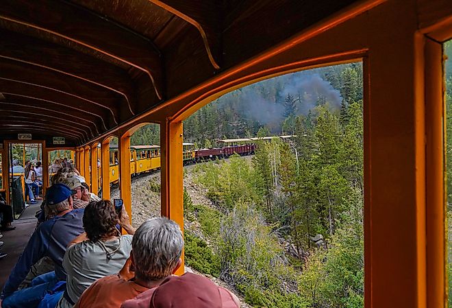 Tourists in a railroad car on the Georgetown Loop Railroad in Georgetown, Colorado. Image credit Bob Pool via Shutterstock.