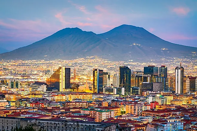 Naples, Italy with the financial district skyline under Mt. Vesuvius at twilight.