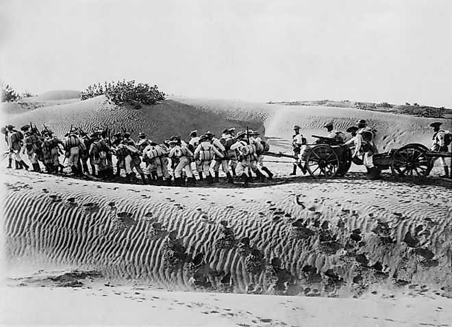 British naval landing party pulling field gun and caisson across the desert. Shutterstock.