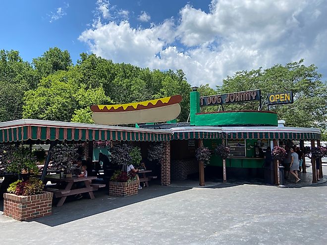 Vintage illustrated and neon signs on the roof of Hot Dog Johnny's roadside stand open on a sunny summer day in New Jersey. Editorial credit: Here Now / Shutterstock.com