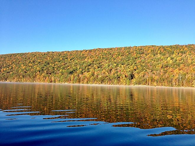 The clear, still waters of the Canadice Lake in New York, during autumn.
