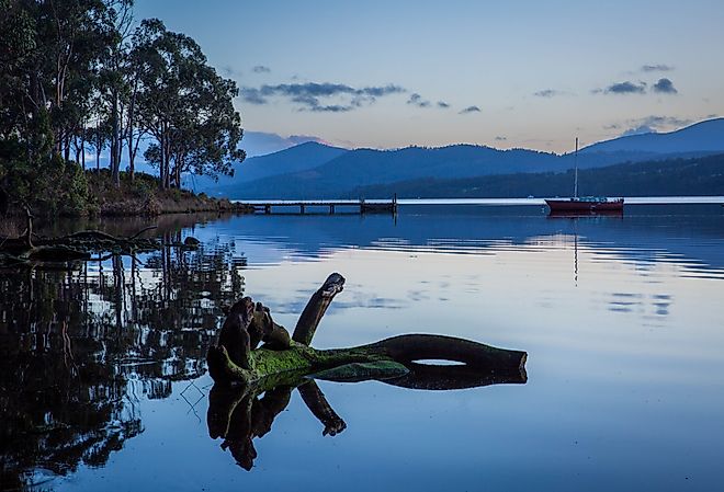 Jetty and fishing boat moored in Huon River, Tasmania, Australia. 