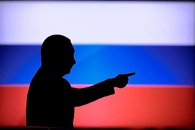 Silhouette of President Vladimir Putin in front of Russian flag.