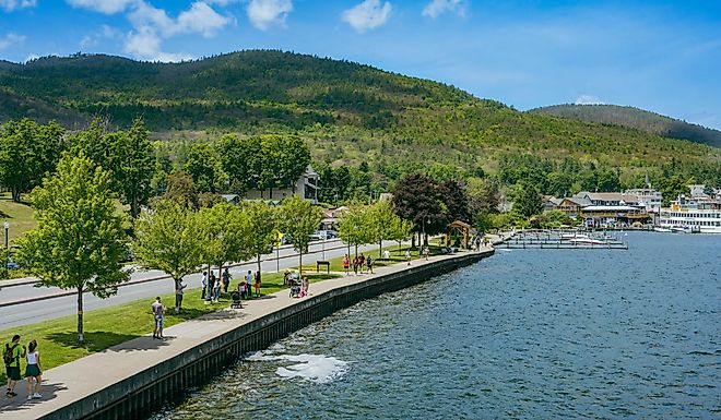 People walking along a path by the water, Lake George, New York.