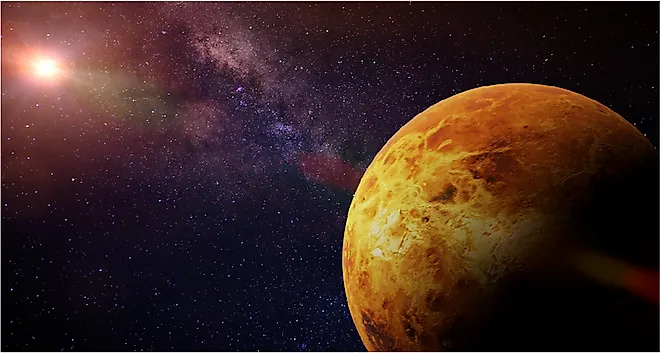 Venus, the slowest-spinning planet in the Solar System, illuminated against the Sun and stars.