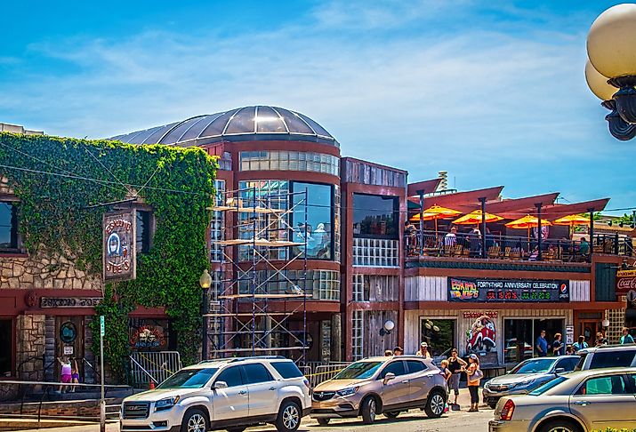 Eskimoo Joes resturant and bar under construction with people standing out front and eating on balcony near Oklahoma State University in Stillwater. Image credit Vineyard Perspective via Shutterstock