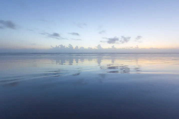 Ocean reflection of dusk sky on the beach. 