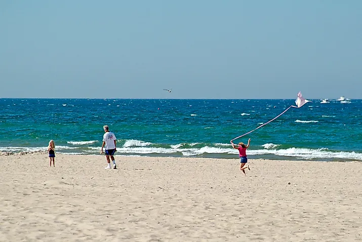 Girl flies kite on beach at Grand Haven State Park on Lake Michigan.