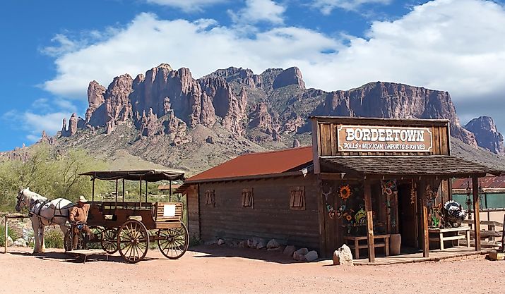 Old Wild West Cowboy town with horse drawn carriage and mountains.