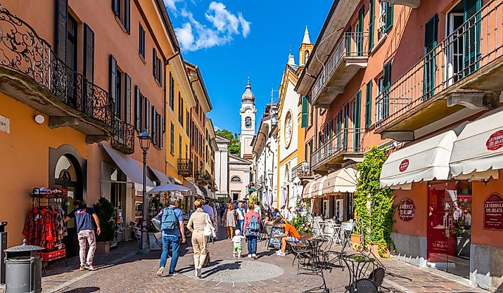 A colorful narrow street of shops and cafes in the medieval old town center of Menaggio, Italy, on the shores of Lake Como. Editorial credit: Kirk Fisher / Shutterstock.com