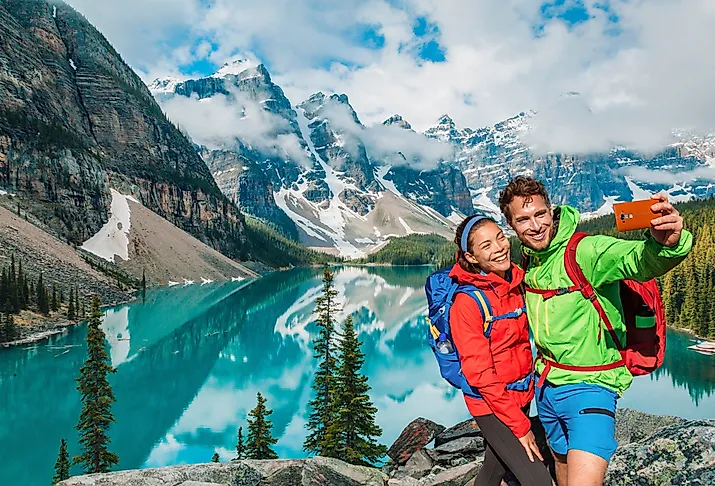 Moraine Lake, tourists taking selfie picture on Canada travel hike.
