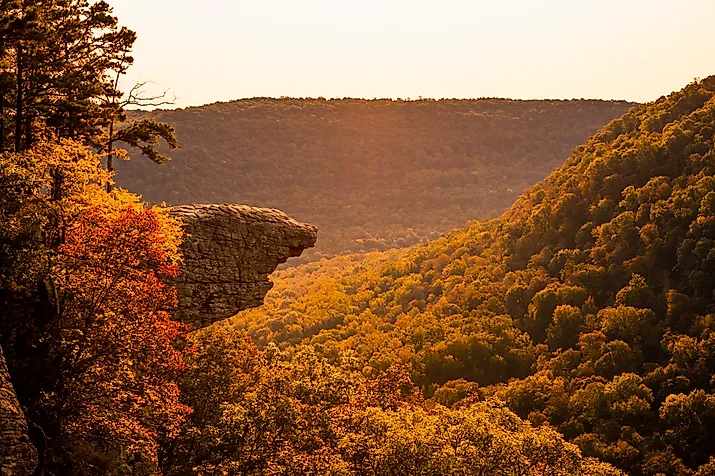 The sun rises over Whitaker Point, known as Hawksbill Crag, in Arkansas as the fall colors begin to set in on the trees. 