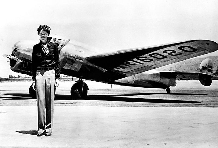 Amelia Earhart standing in front of her Lockheed Electra.