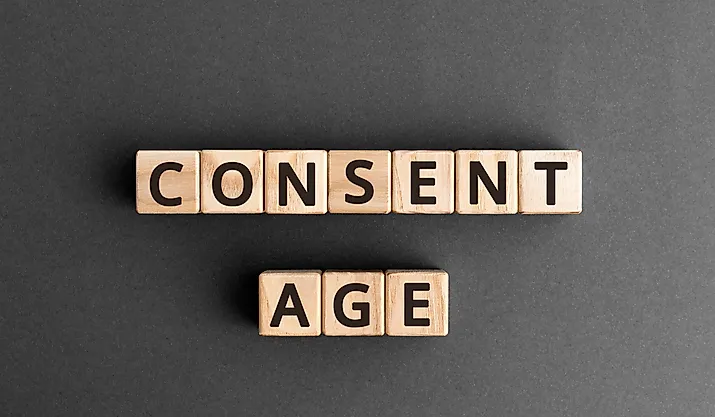The words "Consent Age" formed from wooden blocks with letters.