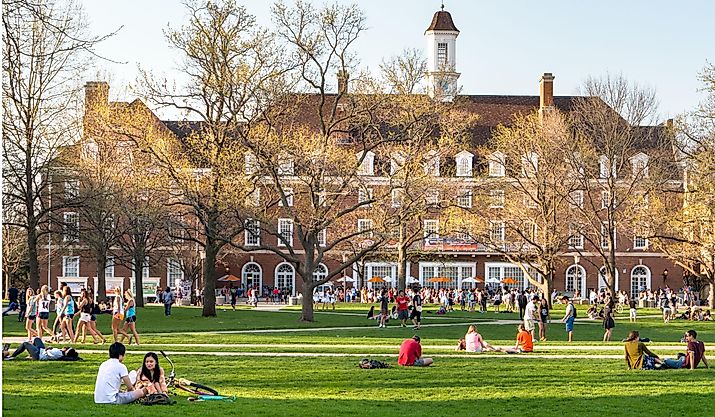Students walk and sit outside on Quad lawn of University of Illinois college campus in Urbana Champaign