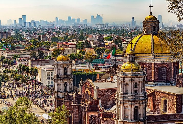 Mexico. Basilica of Our Lady of Guadalupe. Cupolas of the old basilica and cityscape of Mexico City. Image credit WitR via Shutterstock