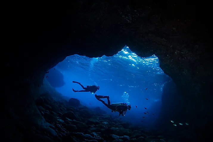 Two female scuba divers at the cave 'Buraco do Inferno' at the archipelago of Fernando de Noronha