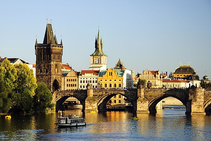 View of Prague behind the Charles Bridge over the Vltava river.