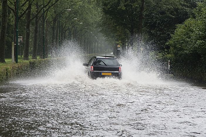 A car driving through a flooded street in the Netherlands. A car driving through a flooded street in the Netherlands.