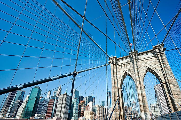 The buildings of New York peak out behind the Brooklyn Bridge. The buildings of New York peak out behind the Brooklyn Bridge.