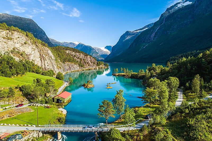 Vista aérea de verão da ponte e casa de barcos na margem do lago mais verde da Noruega - Lovatnet
