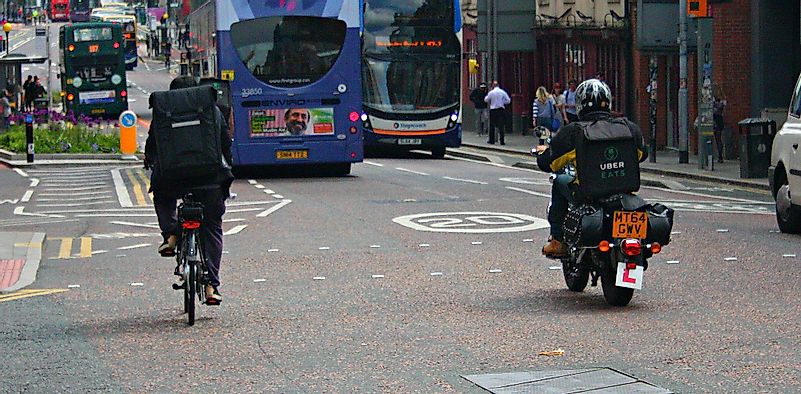 Uber Eats Delivery Drivers - one cycling a bike and one on a motorbike. Image credit: Shopblocks/Flickr.com