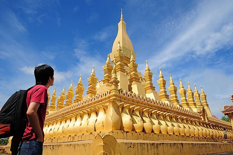 A backpacker stands outside of the Wat Pha-That Luang in Laos. A backpacker stands outside of the Wat Pha-That Luang in Laos.