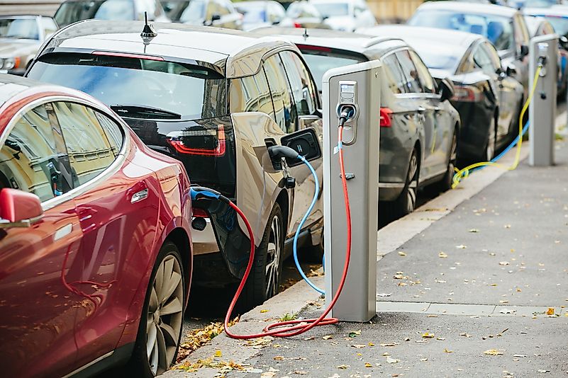 Electric cars charge on the side of the road.