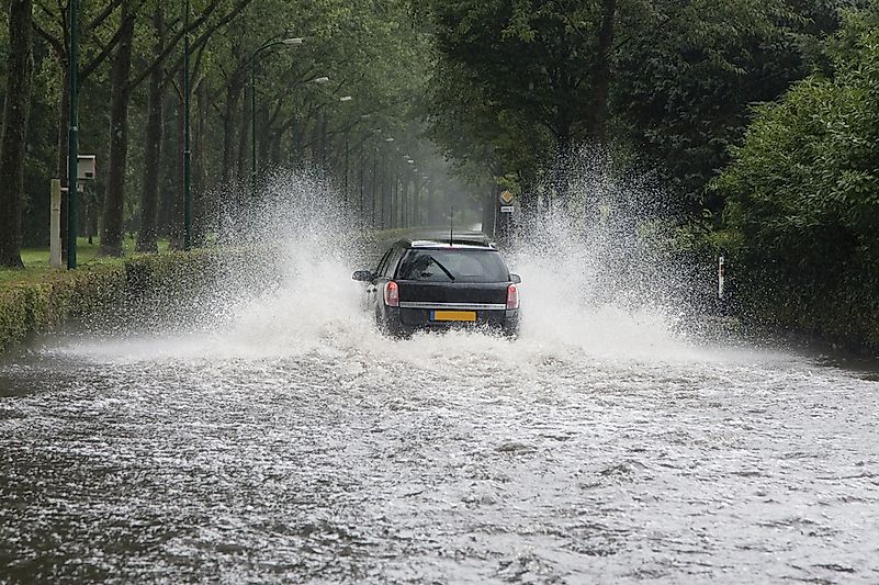 A car driving through a flooded street in the Netherlands. A car driving through a flooded street in the Netherlands.