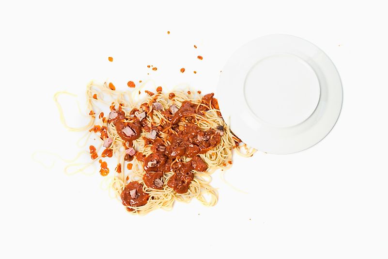 A fallen dish of pasta on the floor