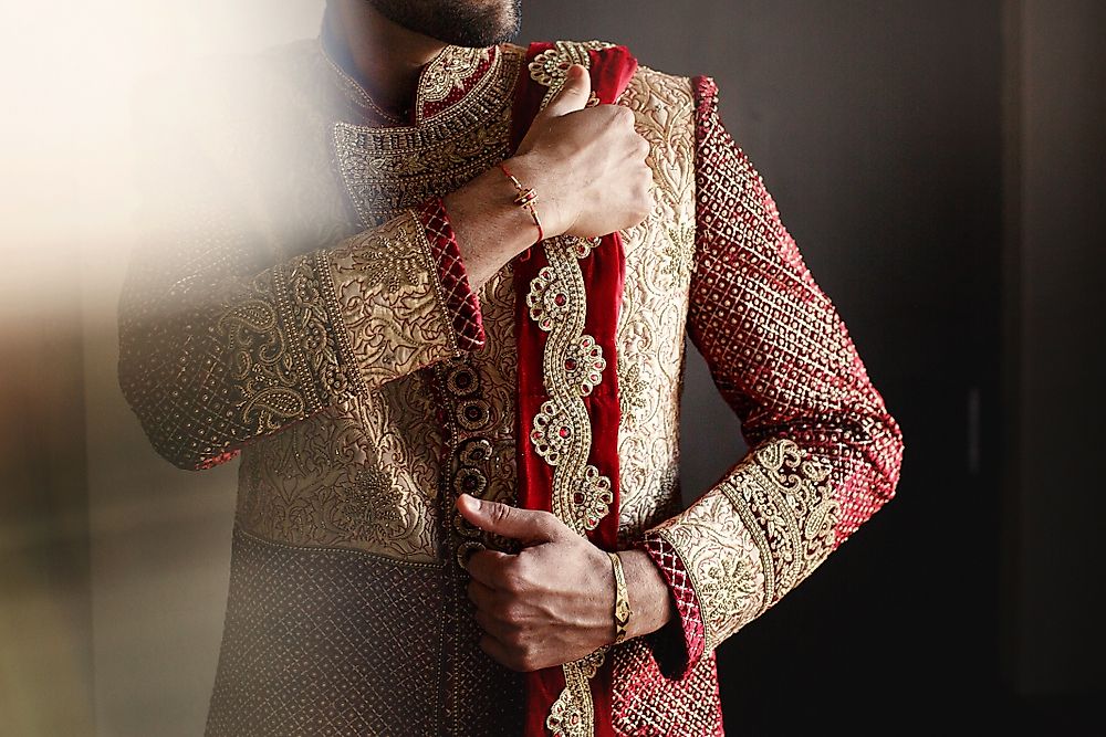 A man wearing a traditional Indian dhoti, photographed on the steps of a temple.