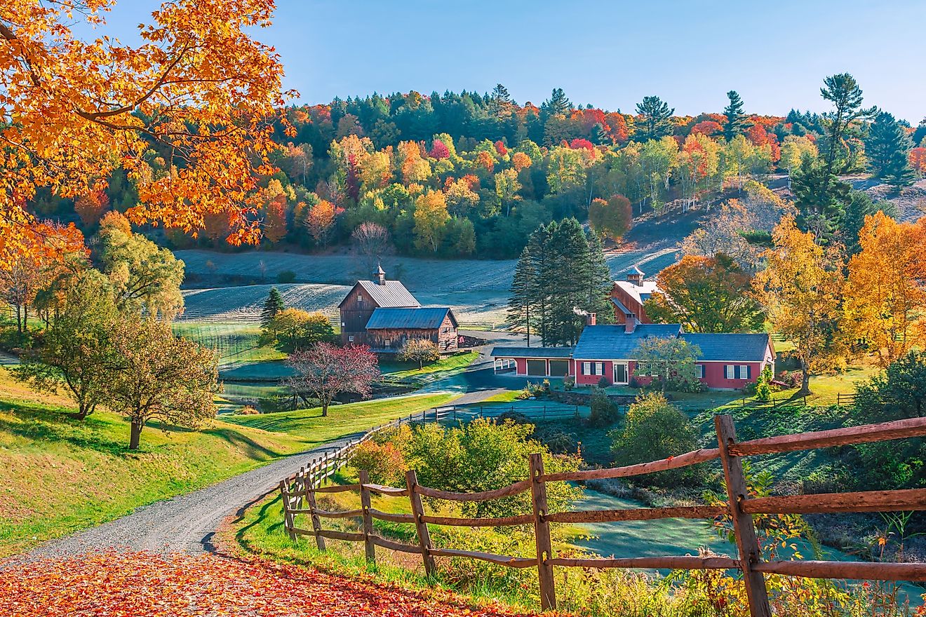 Early autumn foliage scene with houses in Woodstock, Vermont mountains.