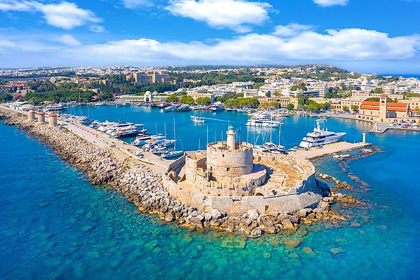 Mandraki port with Fort St. Nicholas and windmills in Rhodes, Greece.