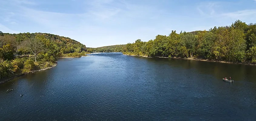 The Delaware River flowing between forested banks.