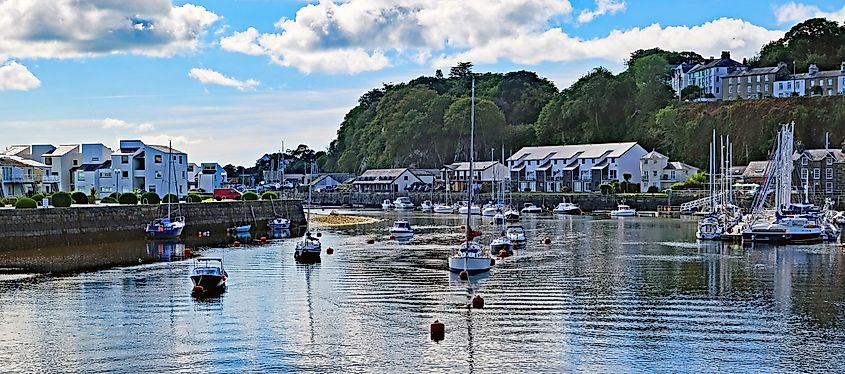Porthmadog, North Wales: Coastal towns harbour or marina with sailing boats and harbour wall. Outdoors on a bright Autumn day.