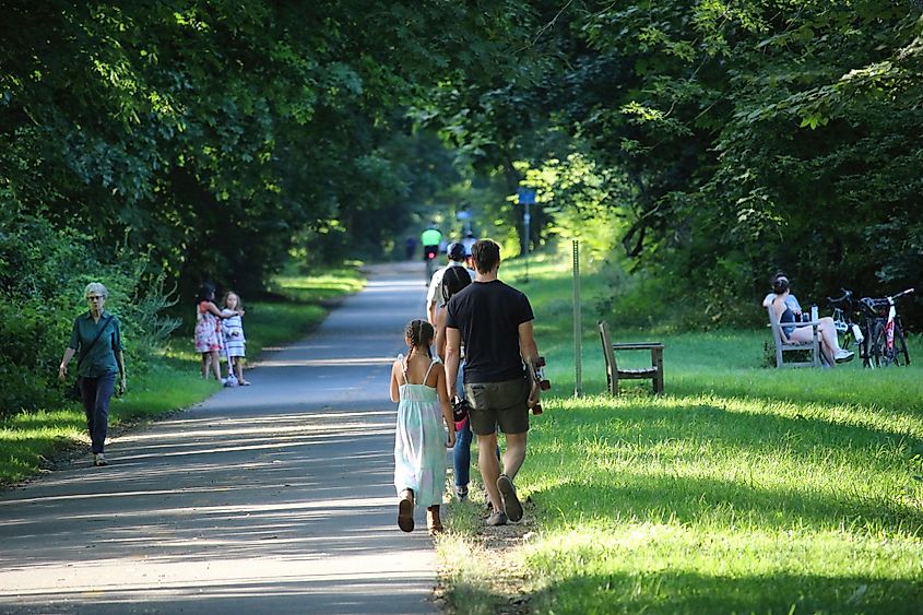 eople cycling, Jogging, walking and sitting in the afternoon on Minuteman Bikeway, Lexington, Maryland.