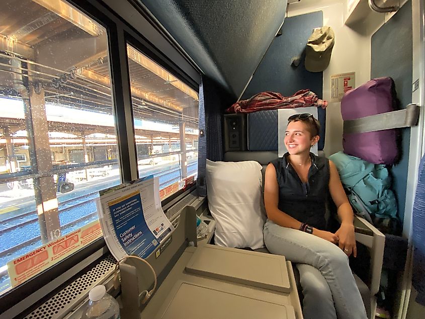 A woman looks out the window from her train roomette.
