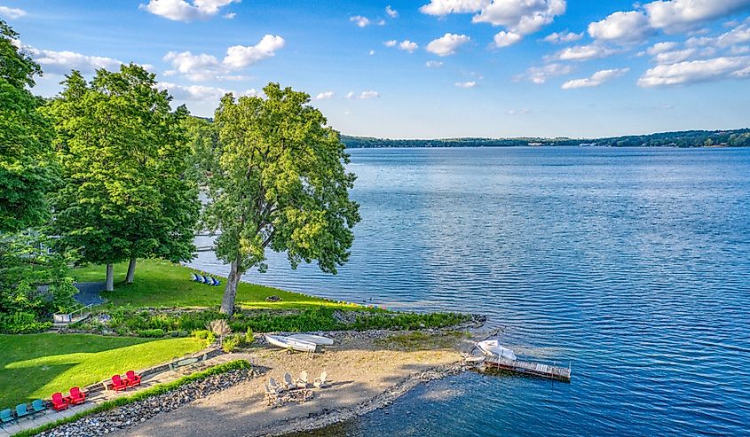 Keuka Lake surrounded by green trees during the summertime.