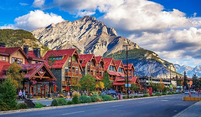 Scenic street view of the Banff Avenue with cars and tourists.