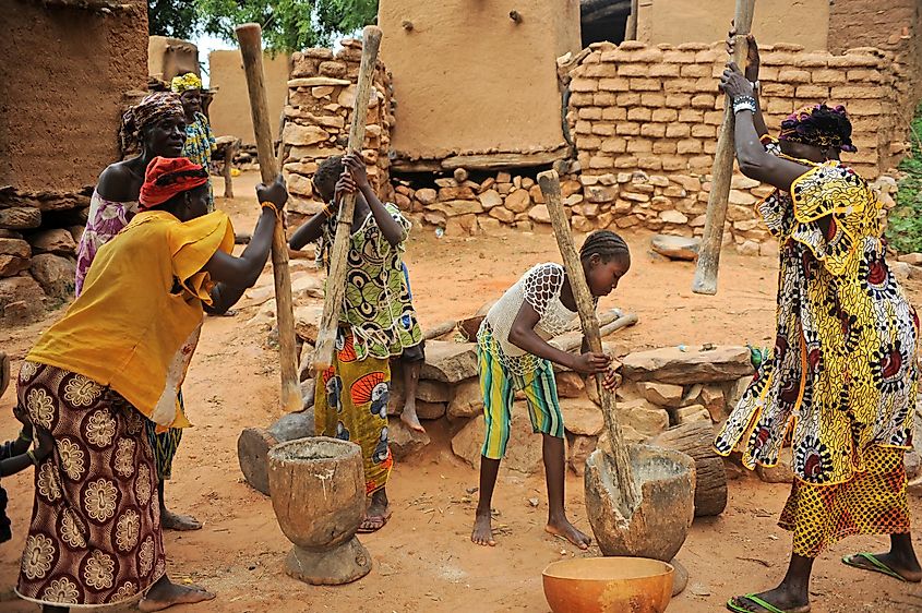 Women and young girls grinding millet in Bandiagara, Mali. 