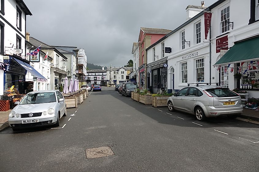 High Street in Crickhowell, Wales, with the war memorial, independent shops, pedestrians, and parked vehicles.