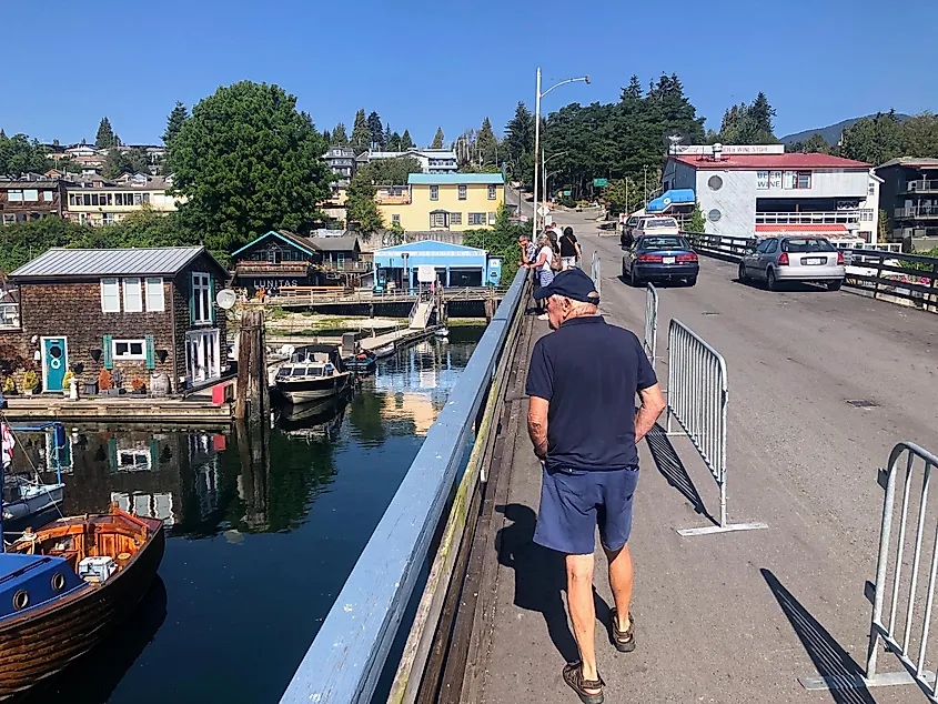A man walking through the beautiful downtown of Gibsons, surrounded by shops and restaurants, along the sunshine coast, British Columbia.