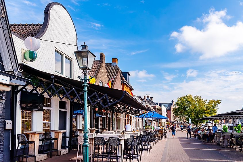 A street in Lemmer, Kortestreek, Netherlands, with historic Dutch buildings and a restaurant along the canal.
