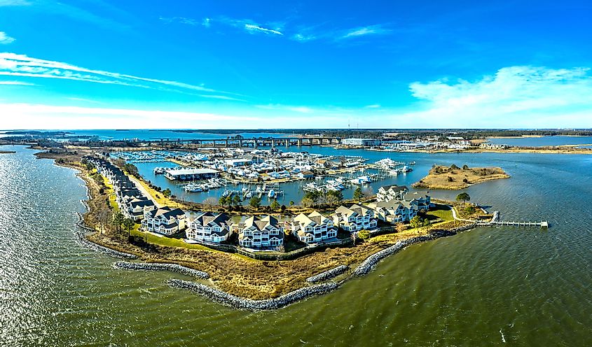 Aerial sunny winter view of luxury duplex residential neighborhood on a manmade promontory with luxury sail boats docked in the marina at Kent Island Narrows Maryland 