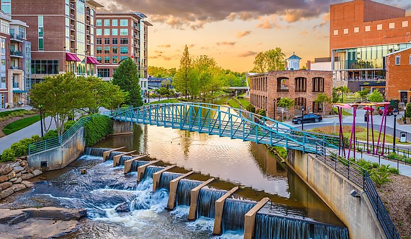 Greenville, South Carolina, US downtown cityscape on the Reedy River at dusk