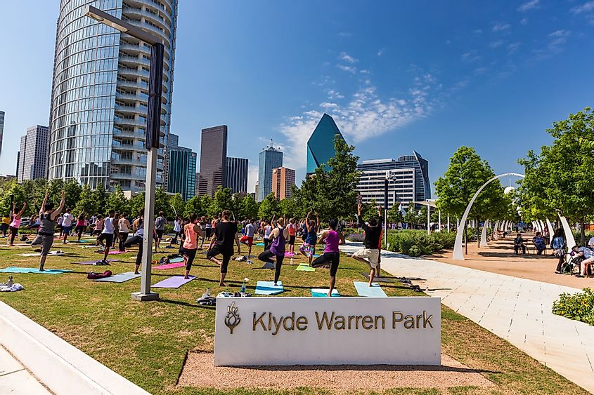 Group of people are doing yoga in Klyde Warren Park in downtown Dallas, Texas