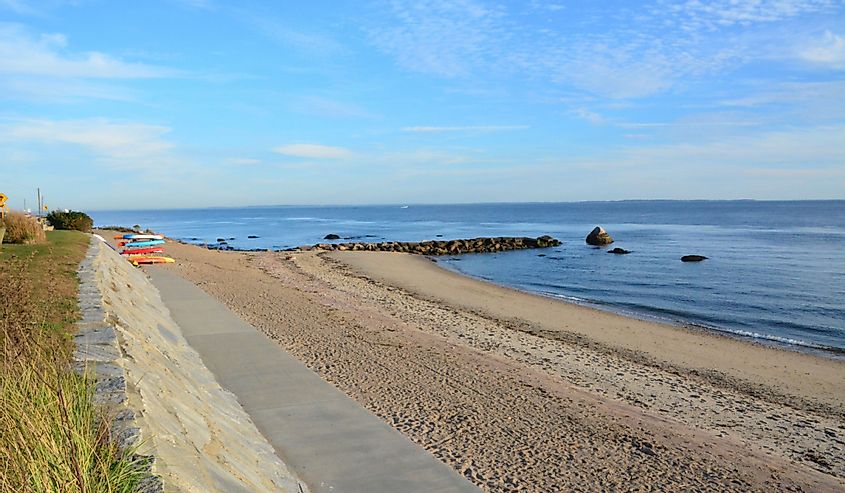 View of the Saybrook Beach with colorful kayaks on the shore in the distance